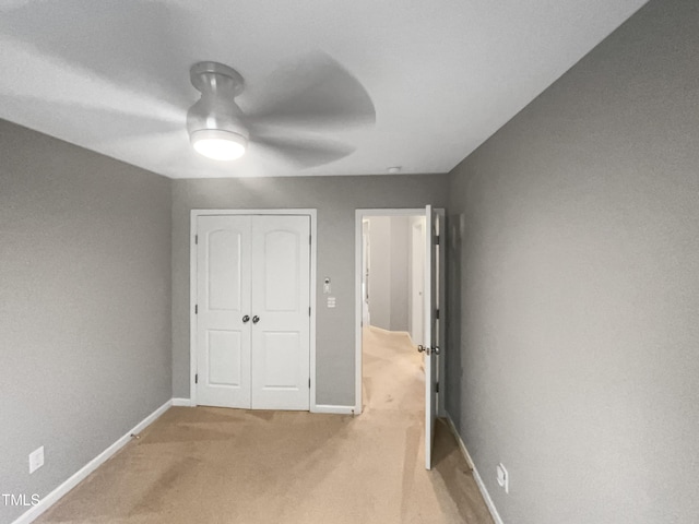 unfurnished bedroom with ceiling fan, a closet, and carpet