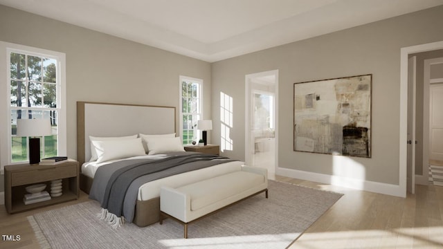 bedroom featuring connected bathroom and light hardwood / wood-style flooring