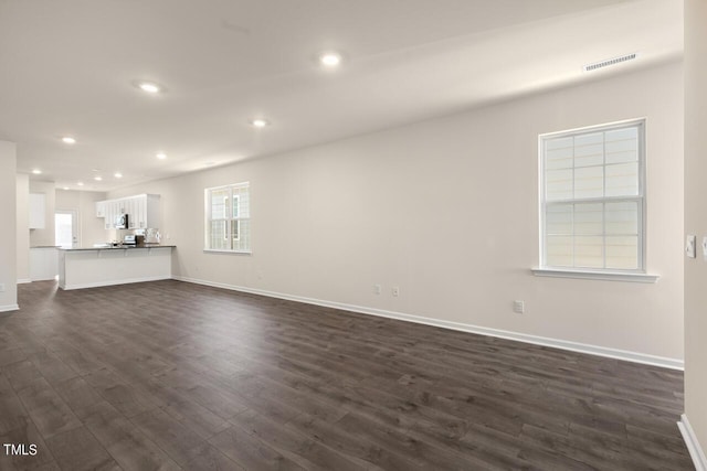 unfurnished living room with dark hardwood / wood-style flooring