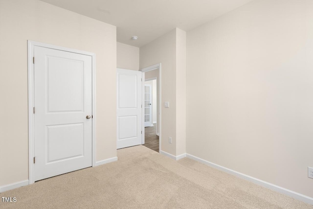 unfurnished bedroom featuring light carpet