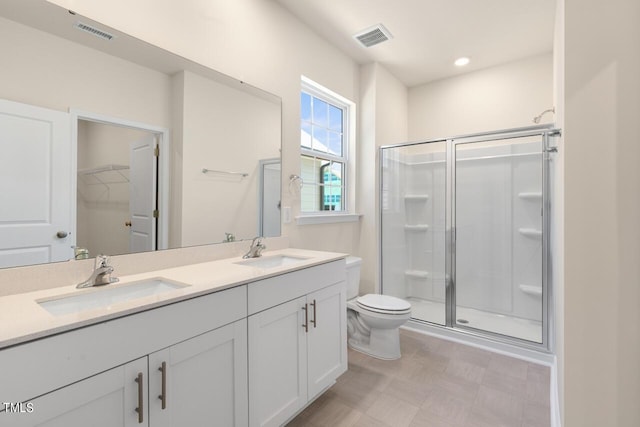 bathroom with toilet, a shower with shower door, and vanity