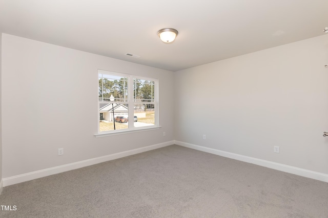 spare room featuring carpet, visible vents, and baseboards