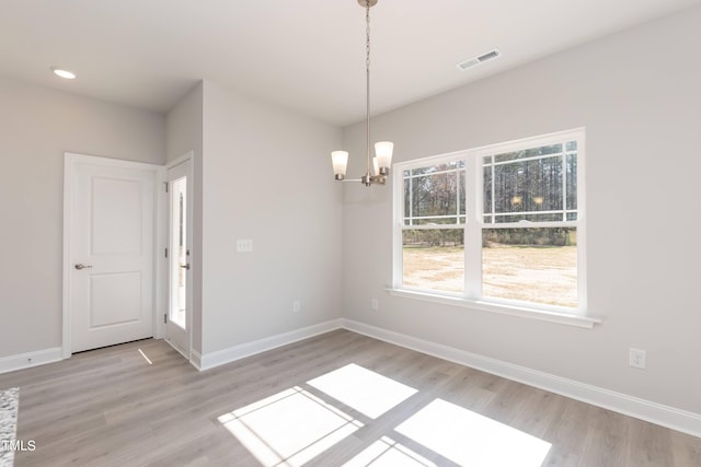 unfurnished dining area with baseboards, visible vents, and light wood finished floors