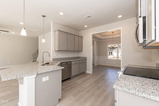 kitchen with sink, light hardwood / wood-style flooring, gray cabinetry, stainless steel appliances, and decorative light fixtures