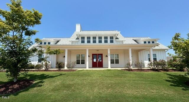 rear view of house with a lawn and a porch