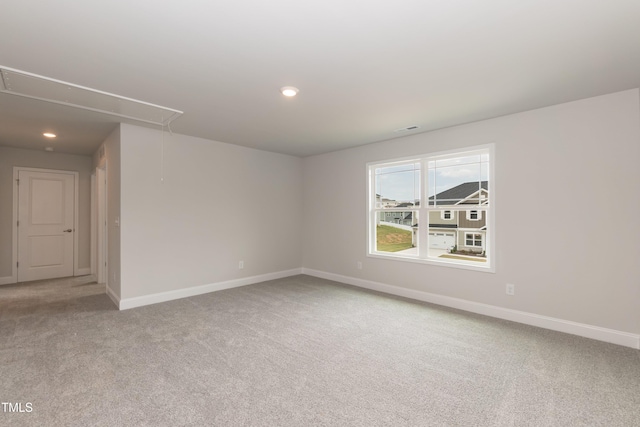 spare room featuring attic access, carpet, baseboards, and recessed lighting