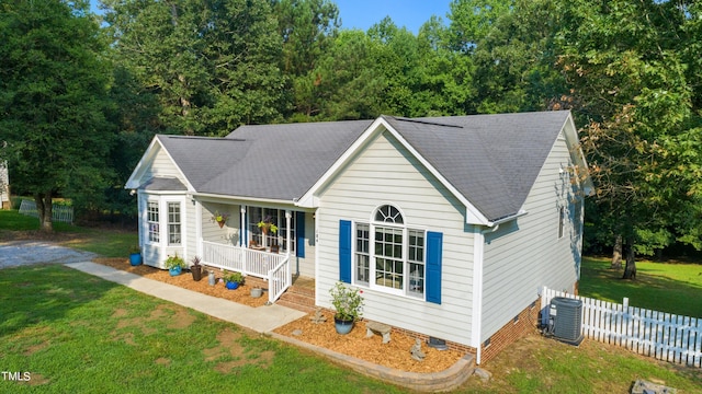 ranch-style home featuring cooling unit, a porch, and a front yard