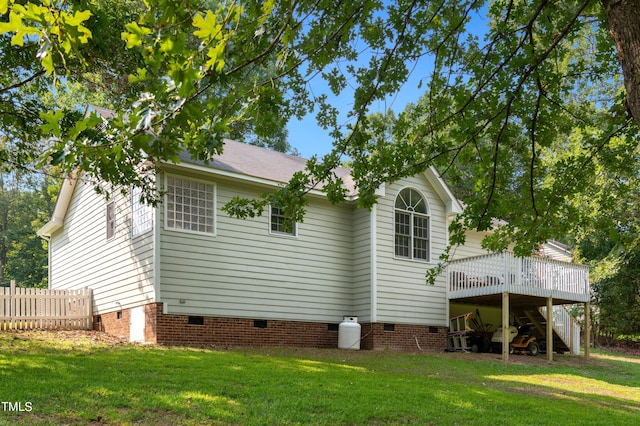 view of home's exterior featuring a wooden deck and a yard