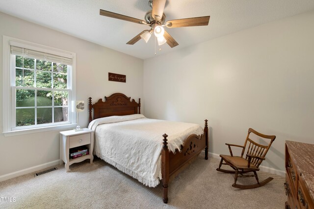 bedroom featuring light colored carpet and ceiling fan