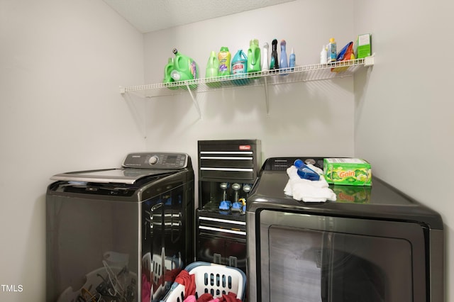 clothes washing area featuring washing machine and clothes dryer and a textured ceiling