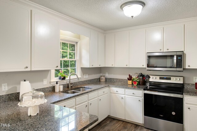 kitchen with stainless steel appliances, sink, white cabinets, and dark stone counters