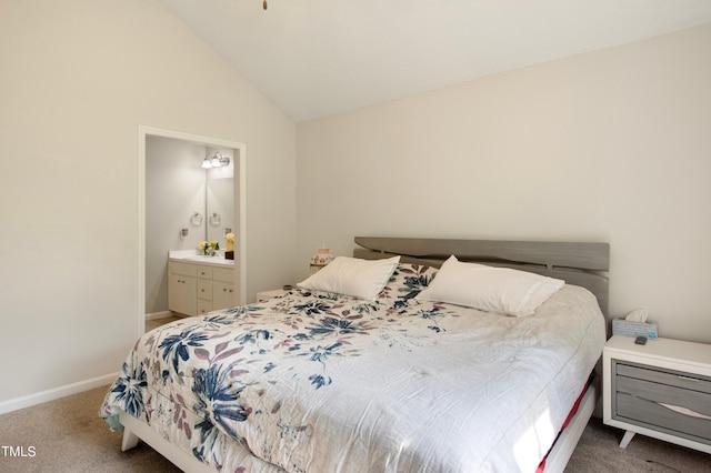 bedroom with vaulted ceiling, carpet, and ensuite bathroom