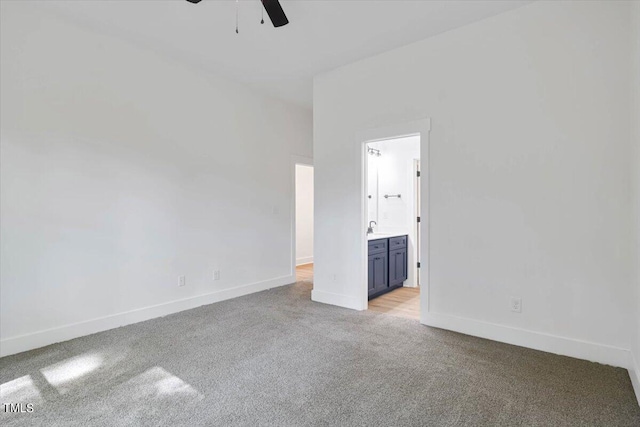 interior space with sink, light colored carpet, and ceiling fan