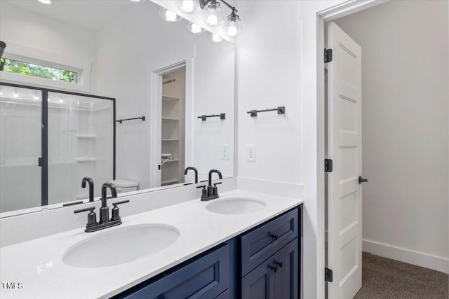 bathroom with vanity, a shower with shower door, and toilet