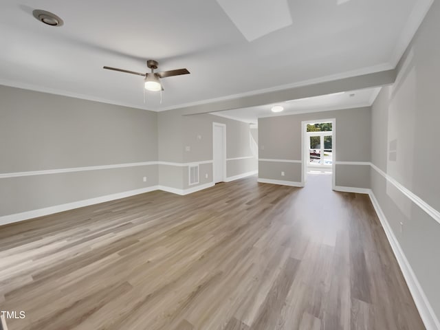unfurnished room featuring a ceiling fan, crown molding, wood finished floors, baseboards, and visible vents