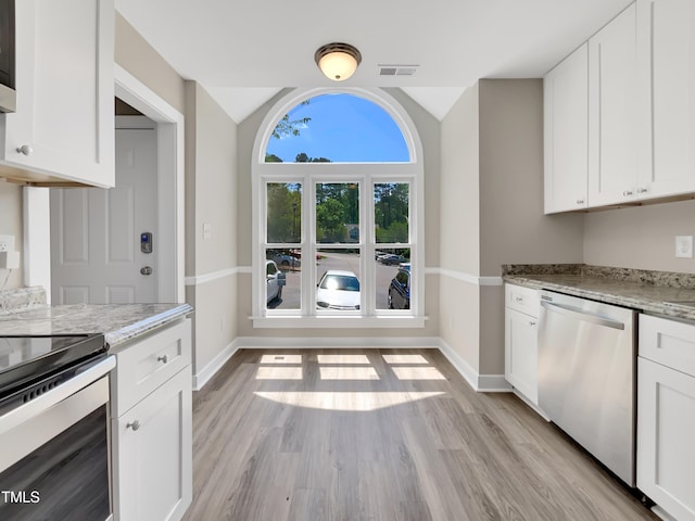 kitchen featuring baseboards, light stone countertops, stainless steel appliances, and visible vents
