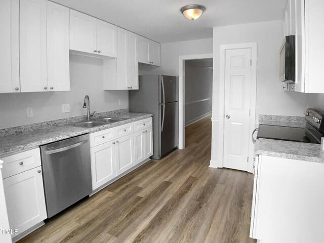 1432 Quarter Pt, Raleigh, NC 27615 - kitchen with stainless steel appliances, white cabinets, and wood finished floors