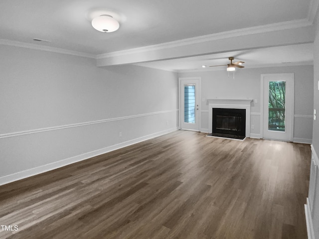 1432 Quarter Pt, Raleigh, NC 27615 - unfurnished living room featuring dark wood-type flooring, ornamental molding, plenty of natural light, a ceiling fan, and a glass covered fireplace