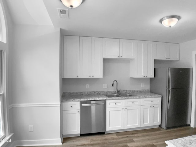 1432 Quarter Pt, Raleigh, NC 27615 - kitchen with appliances with stainless steel finishes, white cabinetry, and light wood-style flooring