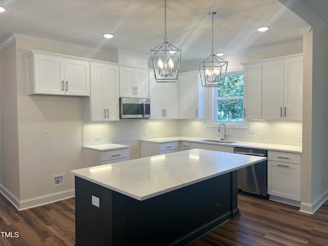 kitchen featuring sink, a kitchen island, white cabinetry, stainless steel appliances, and dark hardwood / wood-style floors