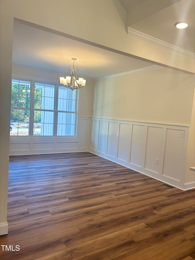 unfurnished room featuring ornamental molding, a chandelier, and dark wood-type flooring