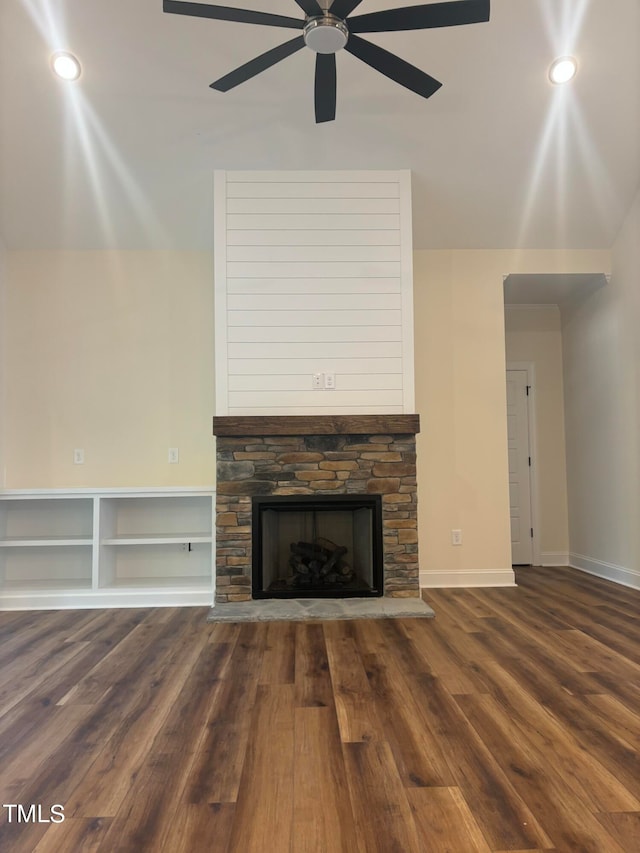 unfurnished living room with ceiling fan, a stone fireplace, and hardwood / wood-style floors