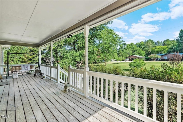 deck featuring covered porch and a yard