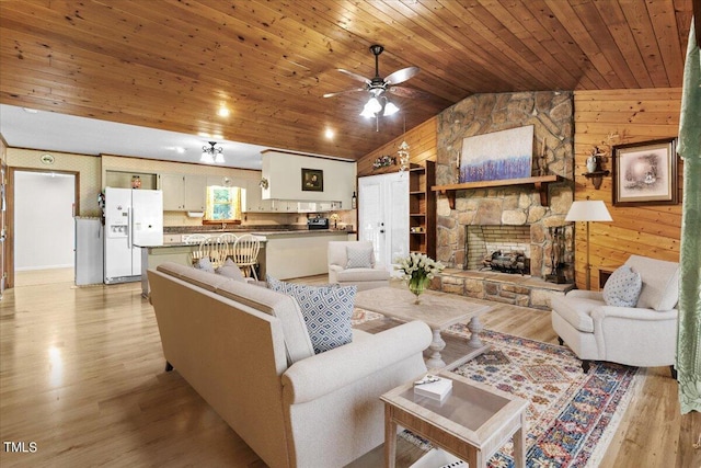 living room with wood ceiling, light hardwood / wood-style floors, wood walls, a fireplace, and vaulted ceiling