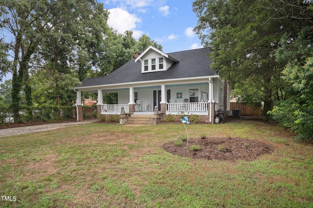 view of front of house featuring cooling unit, a porch, and a front lawn