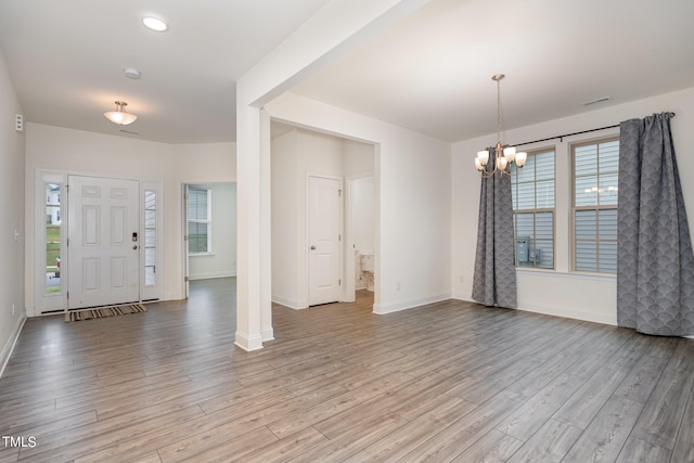 foyer entrance with a chandelier, light wood-type flooring, and a wealth of natural light