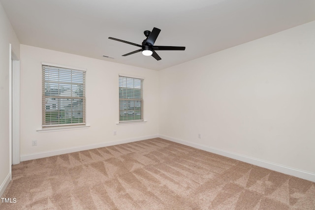 carpeted spare room featuring ceiling fan