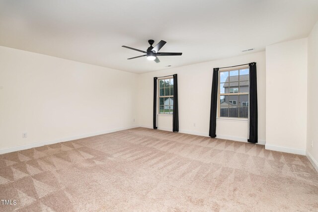 carpeted spare room with ceiling fan