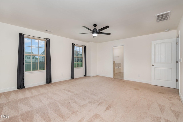 unfurnished bedroom featuring light carpet, ceiling fan, and ensuite bathroom