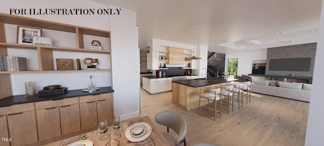 kitchen featuring light hardwood / wood-style floors, sink, a breakfast bar area, and a kitchen island