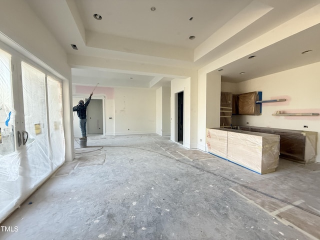 unfurnished living room with a tray ceiling