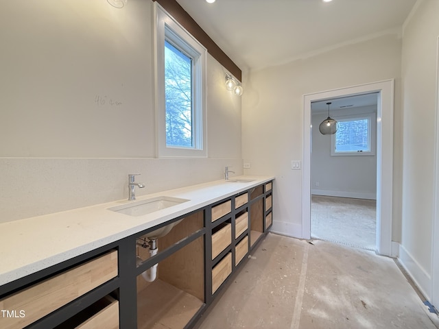 bathroom with double vanity, a sink, and a healthy amount of sunlight