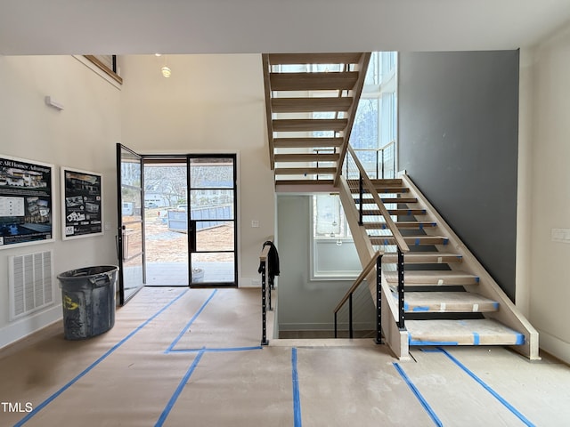 stairway featuring a high ceiling and visible vents