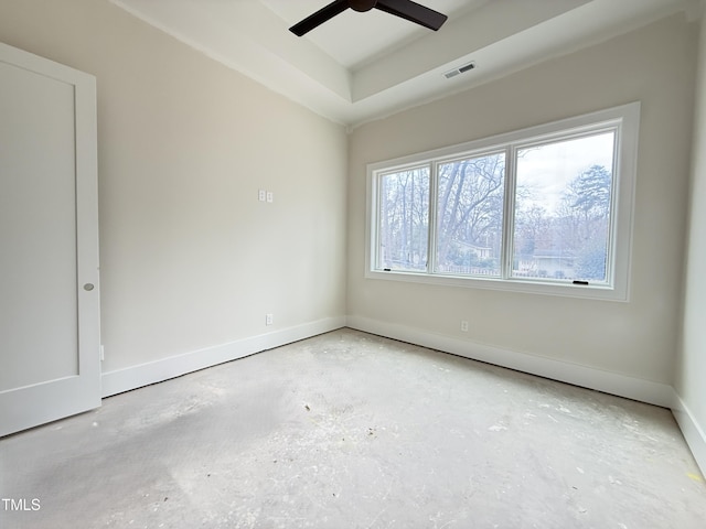 empty room featuring a ceiling fan, a raised ceiling, visible vents, and baseboards