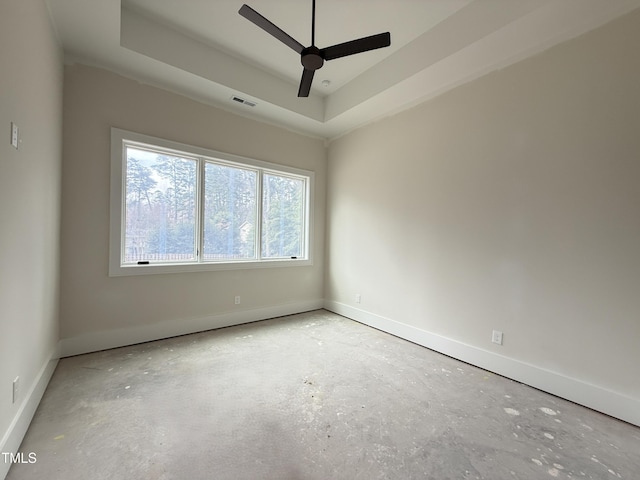 unfurnished room with a raised ceiling, visible vents, ceiling fan, and baseboards