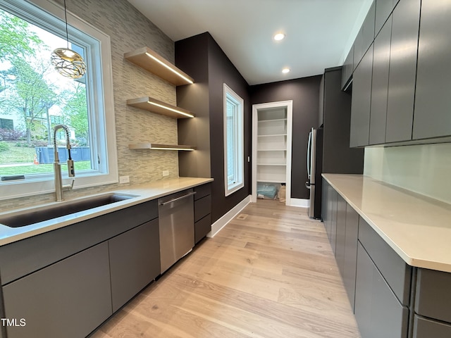 kitchen featuring light countertops, light wood-style floors, a sink, and stainless steel appliances