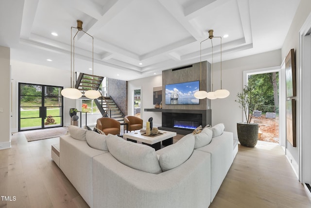 4123 Rockingham Dr, Raleigh, NC 27609 - living area featuring a fireplace, stairway, light wood-type flooring, coffered ceiling, and baseboards