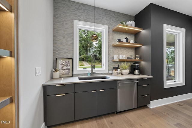 4123 Rockingham Dr, Raleigh, NC 27609 - bar featuring dishwasher, a sink, light wood-type flooring, backsplash, and pendant lighting