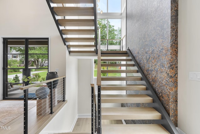 4123 Rockingham Dr, Raleigh, NC 27609 - stairs featuring plenty of natural light, wood finished floors, a towering ceiling, and baseboards