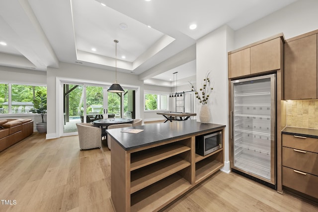 4123 Rockingham Dr, Raleigh, NC 27609 - kitchen with dark countertops, stainless steel microwave, open floor plan, light wood finished floors, and recessed lighting