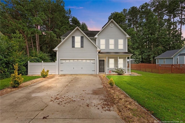 front of property featuring a garage, a lawn, and covered porch