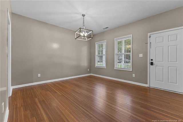 interior space featuring dark wood-type flooring and an inviting chandelier