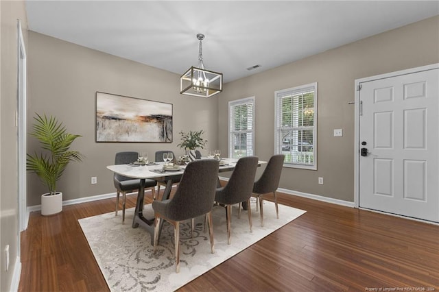 dining area with a chandelier and dark hardwood / wood-style flooring