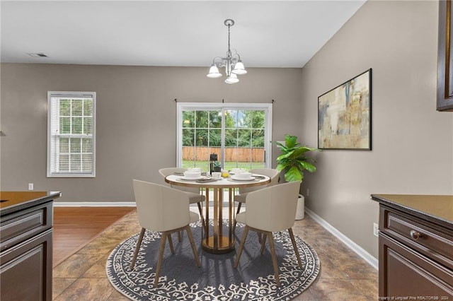 dining room with wood-type flooring, a wealth of natural light, and a chandelier