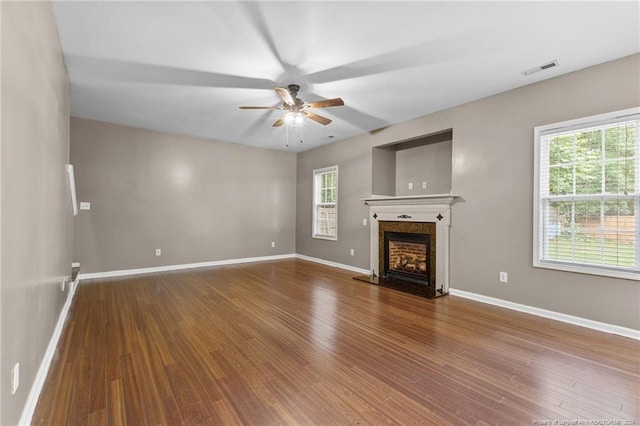 unfurnished living room featuring wood-type flooring and a wealth of natural light