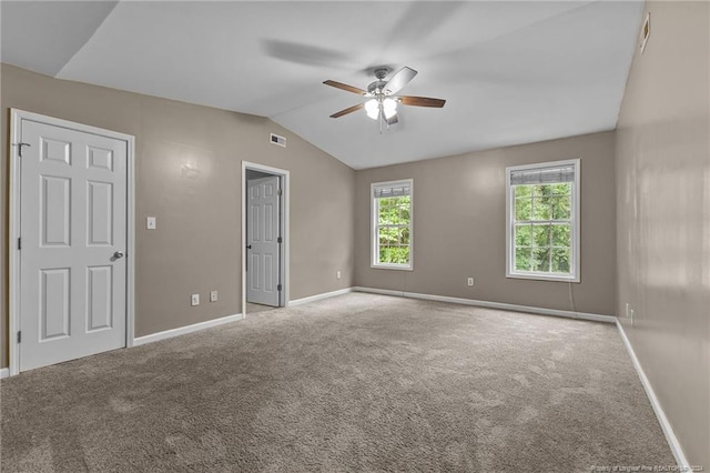 carpeted spare room featuring lofted ceiling and ceiling fan